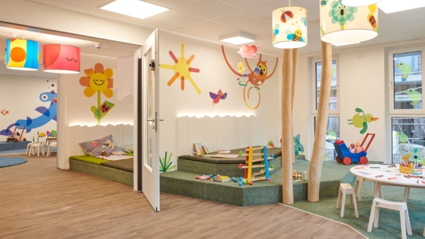 kita-kinderzimmer-klövensteen-hamburg-rissen-raum_023.jpg Gruppenraum mit Birkenstämmen, Spielpodest und Wandmalerei – Kita kinderzimmer Klövensteen, Hamburg-Rissen