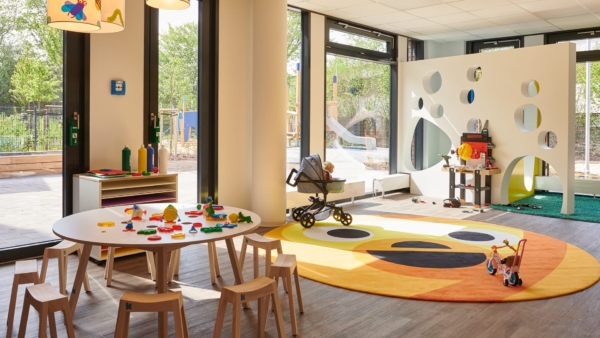 kita-kinderzimmer-schierenberg-hamburg-rahlstedt-raum-062.jpg Gruppenraum mit rundem Tisch und gelbem Teppich – Kita kinderzimmer Schierenberg, Hamburg-Rahlstedt