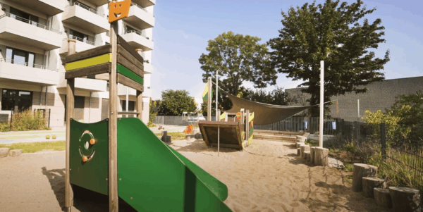 kita-kinderzimmer-schilfpark-hamburg-bergedorf-außengelaende-4 Spielplatz mit Kletterturm und Sandkasten in der Kita Hamburg.