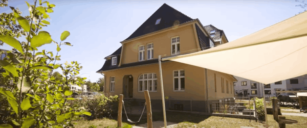 Häuseransicht im Hamburger Stadtteil Gelbes Haus mit Garten und Sonnenschutz im Freien.