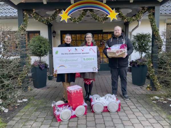 Übergabe eines großen Spendenschecks und gebastelten Weihnachtsgeschenken vor dem Kinderhospiz Sternenbrücke in Hamburg Rissen