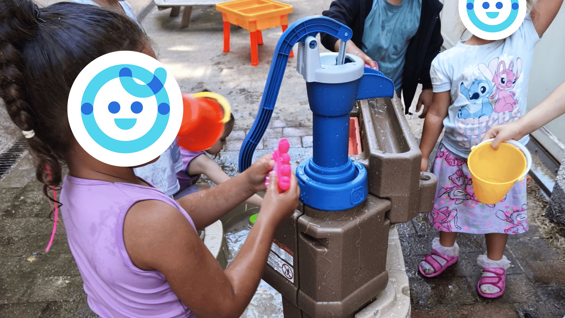Kinder spielen mit einer Wasserpumpe in der Kita kinderzimmer Eißendorf in Hamburg Eißendorf